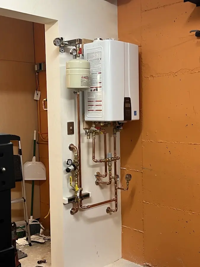 Plumbing technician inspecting water heater connections in Long View